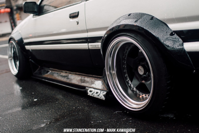 parking, AE86, travel, metal, transportation, land vehicle, car, chrome, vehicle part, close-up, motor vehicle, city, focus on foreground, gray, road, black