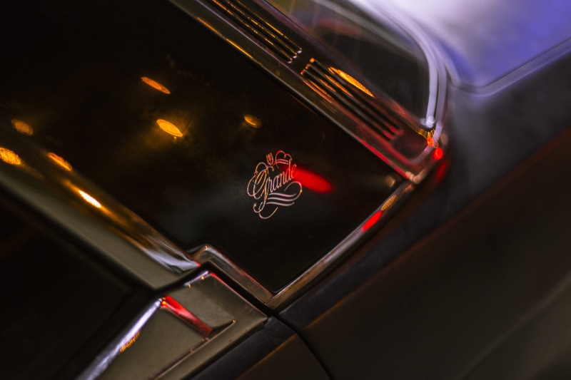 car wheel, automobile, high angle view, reflection, no people, tail light, glass - material, black, luxury, machine, trademark, night, vehicle, spoke, alloy wheel