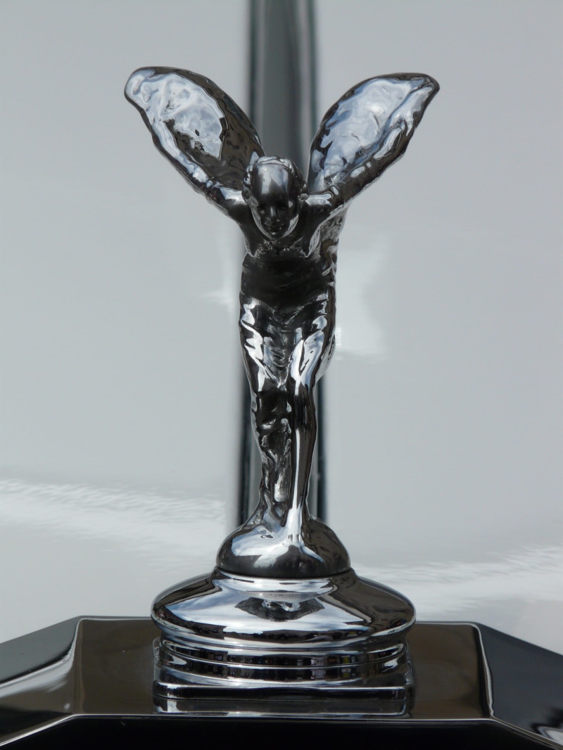cool figure, motion, art and craft, sculpture, flowing, close-up, spirit of ecstasy, silver colored, focus on foreground, indoors, rolls royce, automotive