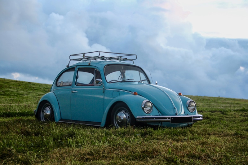 bug, cloud - sky, stationary, roof rack, retro styled, automobile, travel, bude, no people, grass, outdoors, gravel, road, vehicle, day, volkswagen, hill