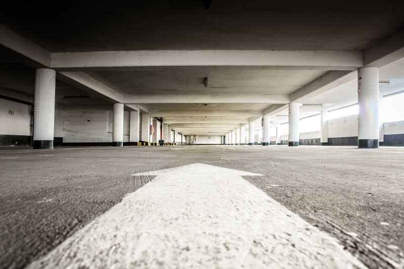 photography, symmetry, surface level, landscape, diminishing perspective, ceiling, arrow, in a row, road, parking garage, long, parking, transportation