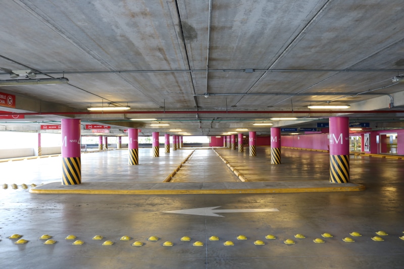 architectural column, empty, reflection, diminishing perspective, lighting equipment, transportation, lights, parking, arrow, indoors, illuminated, parking garage
