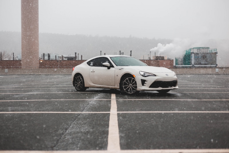 snowing, car, rain, concrete, nature, no people, machine, alloy wheel, tire, parking, motor vehicle, automobile, outdoors, sky, parking lot, city, 5K