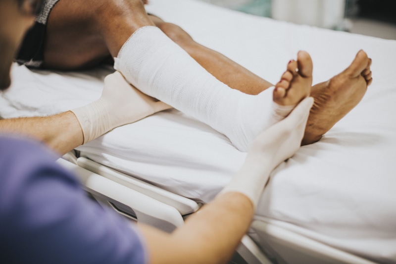 two people, low section, treatment, women, wear, wellbeing, professional, male, physician, bed, reclining, orthopedic, patient, ill, people, room, african