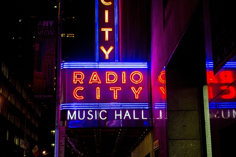 rockettes, night, neon, entertainment, text, information, advertisement, illuminated, glowing, multi colored, lighting equipment, city, sign, lights, neon lights