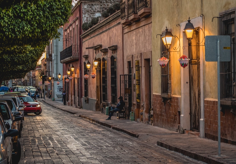 incidental people, motor vehicle, architecture, car, illuminated, building, parking, paved, mode of transportation, built structure, transportation, city street