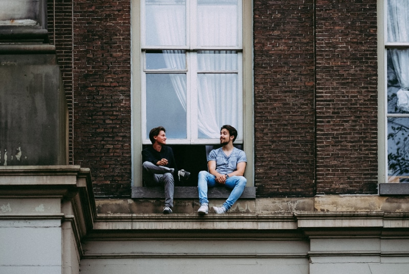 men, adult, relaxation, man, building exterior, casual clothing, technology, women, outdoors, sitting, friendship, full length, young adult, architecture