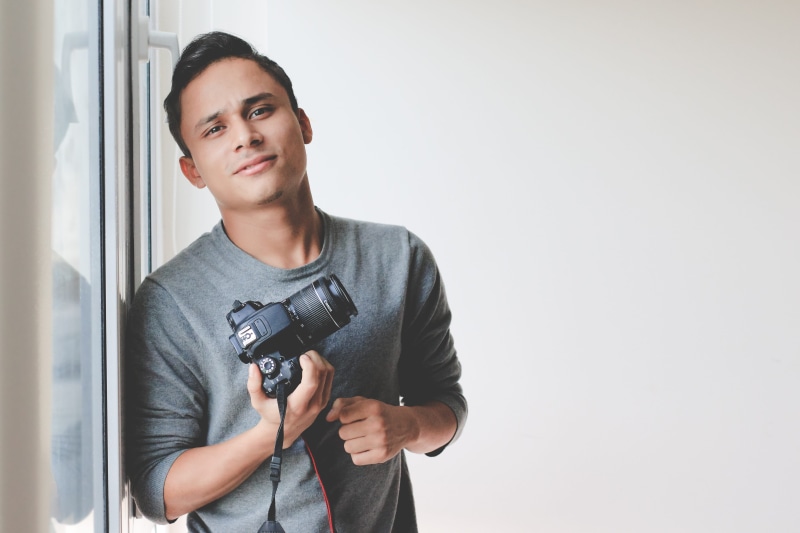 photographic equipment, standing, looking at camera, front view, windowpane, photographing, digital camera, portrait, slr camera, photographer, casual clothing