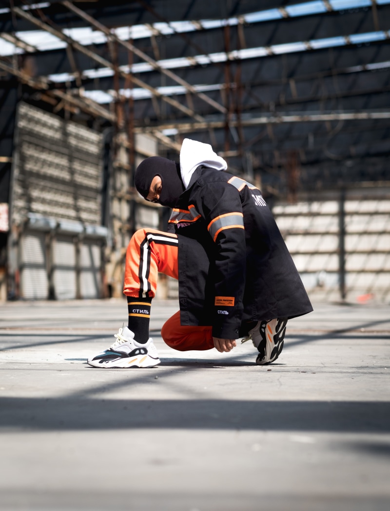 shoe, rear view, men, young, sock, full length, person, man, architecture, kneel, orange, pants, fierce, intense, mask, people, two people, real people