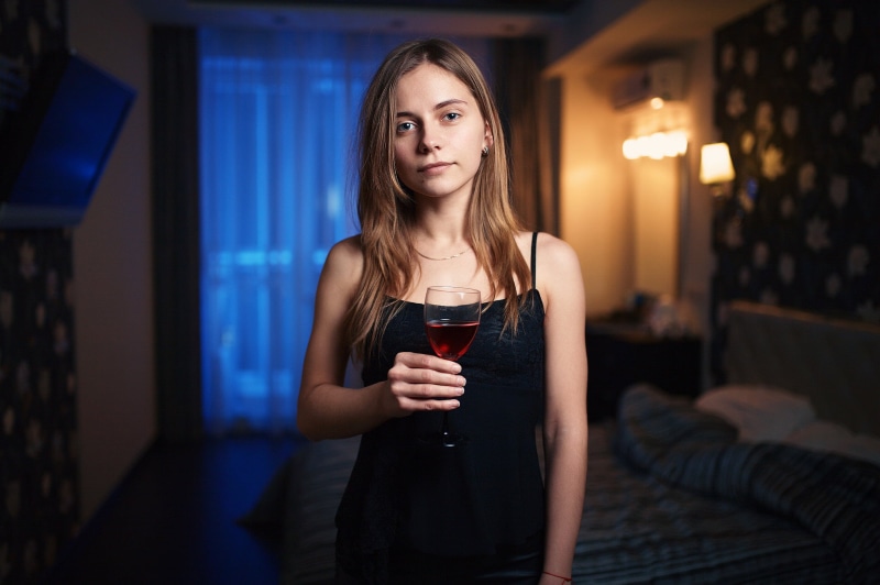 food and drink, long hair, red wine, beautiful woman, drinking, portrait, alcohol, beauty, blue eyes, contemplation, black tops, hair, indoors, waist up