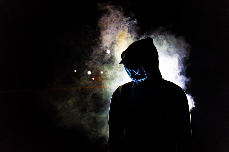 illuminated, 5K, depression - sadness, waist up, led lights, headshot, smoky, fog, one person, darkness, standing, black background, male, mist, cap, mask