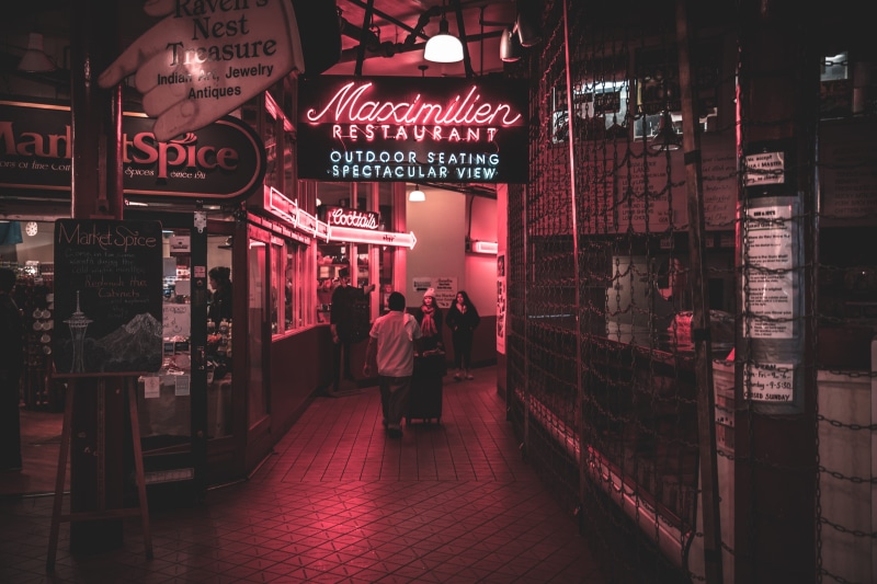 built structure, lobby, western script, text, illuminated, restaurant, sign, building exterior, footpath, communication, light, people, neon, city Life