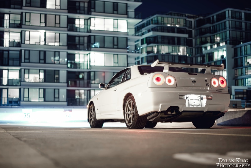 selective focus, Nissan, Nissan Skyline GT-R R34, garage, transportation, land vehicle, car, street, racecar, speed, no people, building exterior, road
