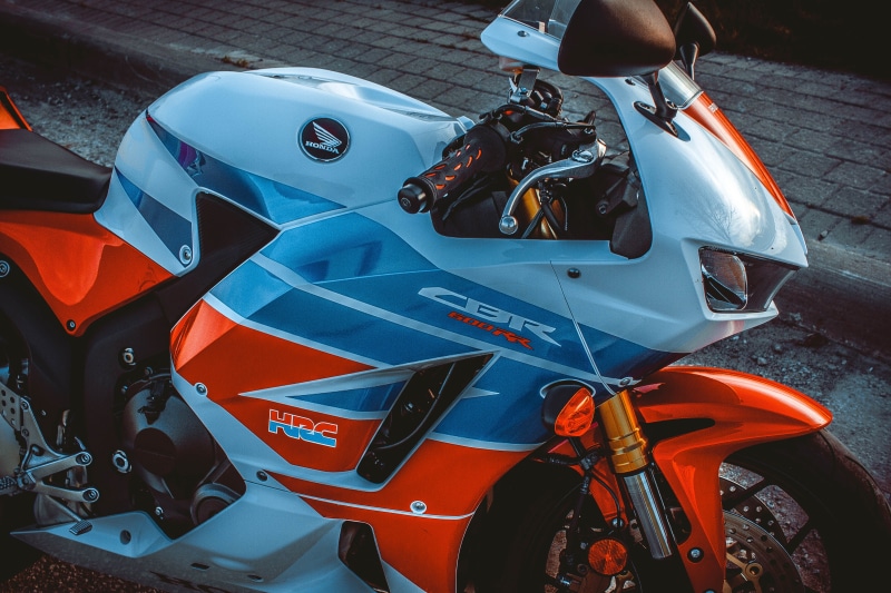 motorcycle, clothing, crash helmet, day, wheel, apparel, motor scooter, cbr, helmet, mode of transportation, outdoors, blue, spoke, no people, alloy wheel