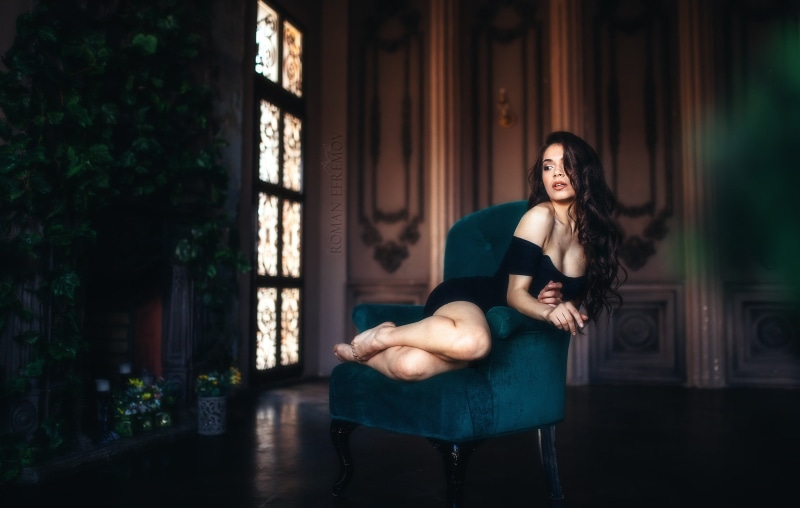 one person, young adult, fashion, black dress, contemplation, full length, young women, hairstyle, armchair, looking away, real people, beautiful woman