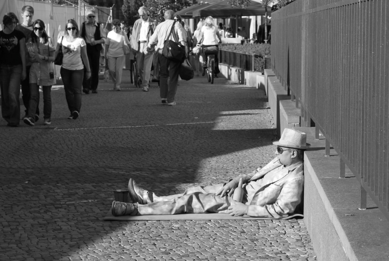 real people, 4K, pantomime, pavement, city scene, figure, day, street scene, representation, black and white, waiting, lying, man, floor, people, large group of people