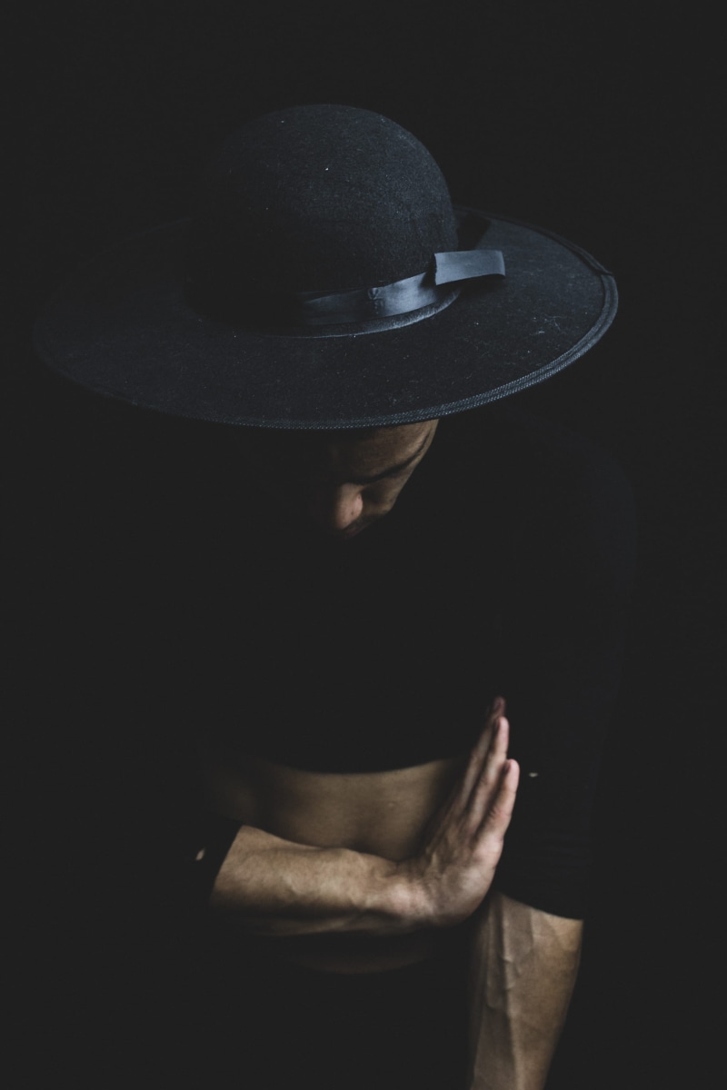 lifestyles, portrait, black hat, darkroom, pose, fashion model, men, photoshoot, adult, wear, indoors, black background, high angle view, 2K, gesture