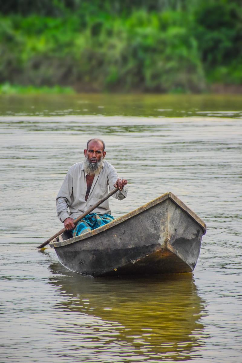 fishing, real people, bangla, waterfront, old boat man, lake, mode of transportation, summer, clouds, travel, day, adult, leisure activity, mature adult