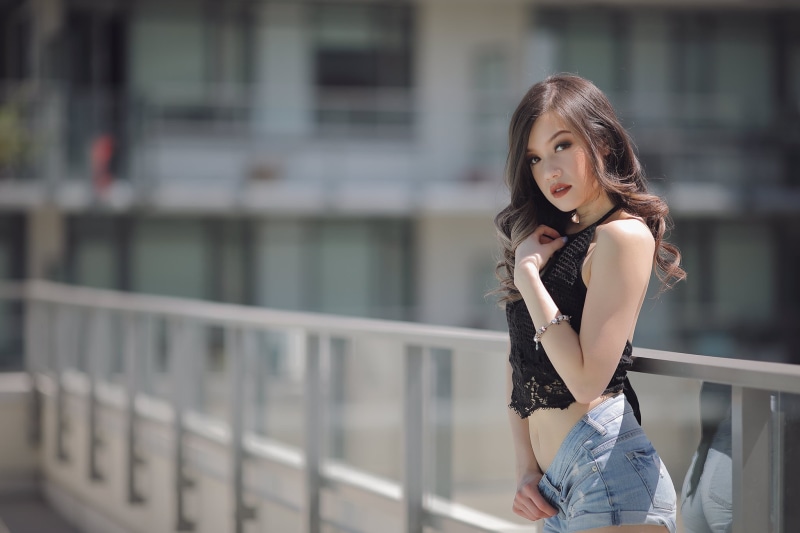 focus on foreground, Asian, looking at camera, teenager, railing, beautiful woman, lifestyles, three quarter length, architecture, belly, long hair, women