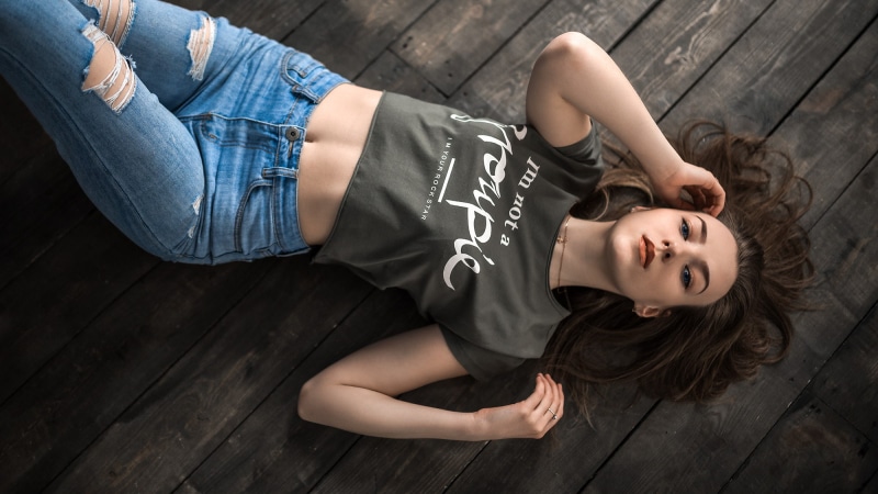 T-shirt, belly, lying on front, women, wooden surface, torn jeans, necklace, top view, blue eyes, 1080P, ripped clothes