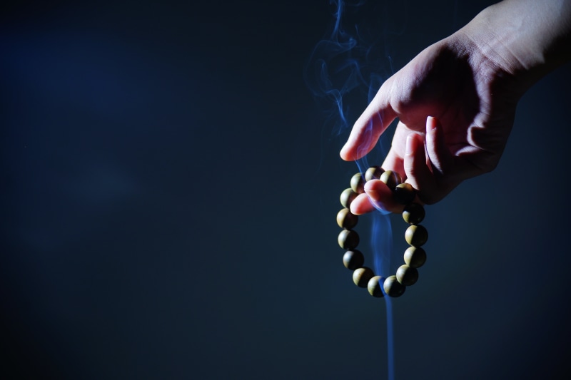 beaded, holding, wrist, human limb, healthcare and medicine, bracelet, buddhist prayer beads, bead, human joint, copy space, finger, black background, zen