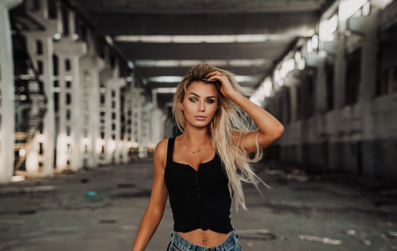 casual clothing, arms raised, necklace, blonde, young women, young adult, blond hair, architectural column, pierced navel, focus on foreground, beautiful woman