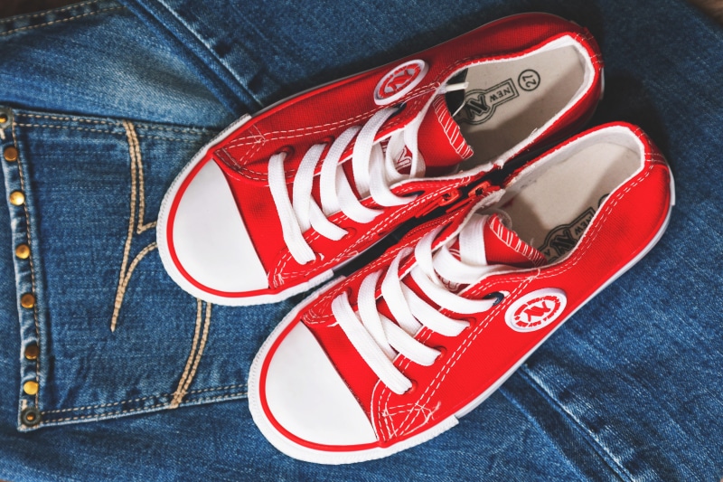 jeans, indoors, 2K, textile, red, casual Clothing, human body part, lifestyles, shoes, fashion, blue, text, one person, clothing, communication, canvas Shoe