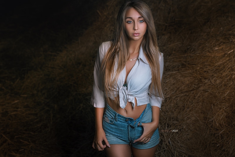 Alexander Drobkov, 2K, model, belly, depth of field, pierced navel, shirt, long hair, jean shorts, brunette, looking away, blue eyes, cleavage, necklace
