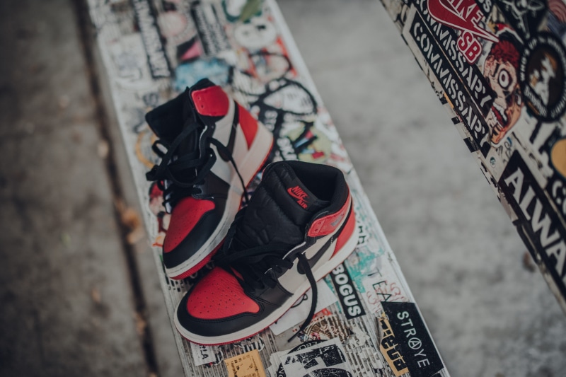 shoe, outdoors, helmet, bench, selective focus, sports equipment, focus on foreground, leisure activity, bicycle, air, high angle view, real people, pair