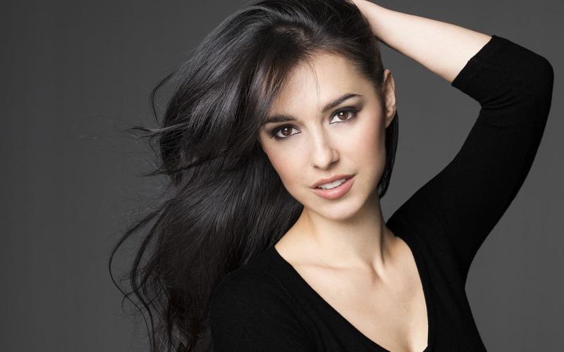 sleeved, neck, looking at camera, hair, arms up, beautiful woman, beauty, black background, black clothing, front view, indoors, black color, top, headshot