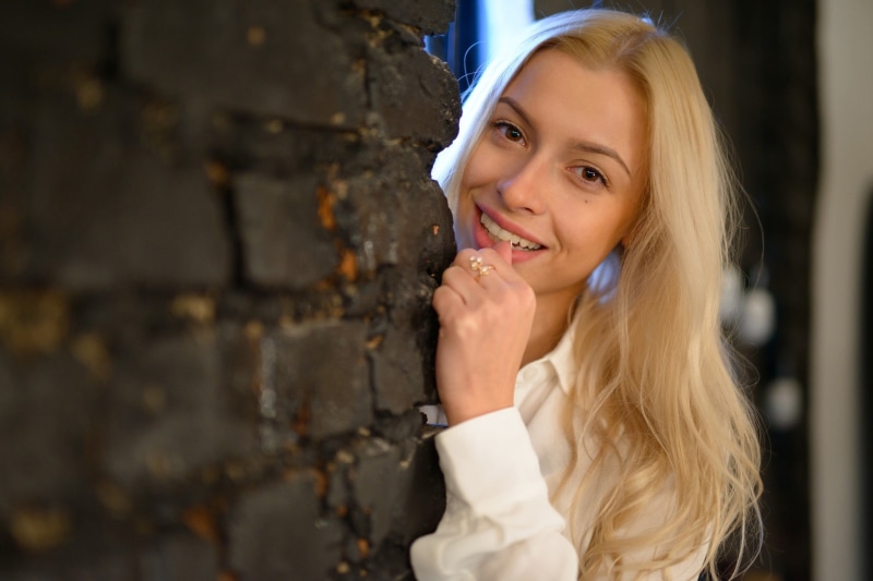 bricks, smiling, face, wall, blonde, women, model, portrait, long hair, Anton Pechkurov, 1080P, Olga Kuzmenkova