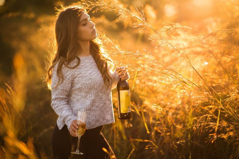 drinking glass, beautiful woman, sunlight, standing, Christopher Rankin, nature, women outdoors, outdoors, one person, young women, sunset, bottles, casual clothing