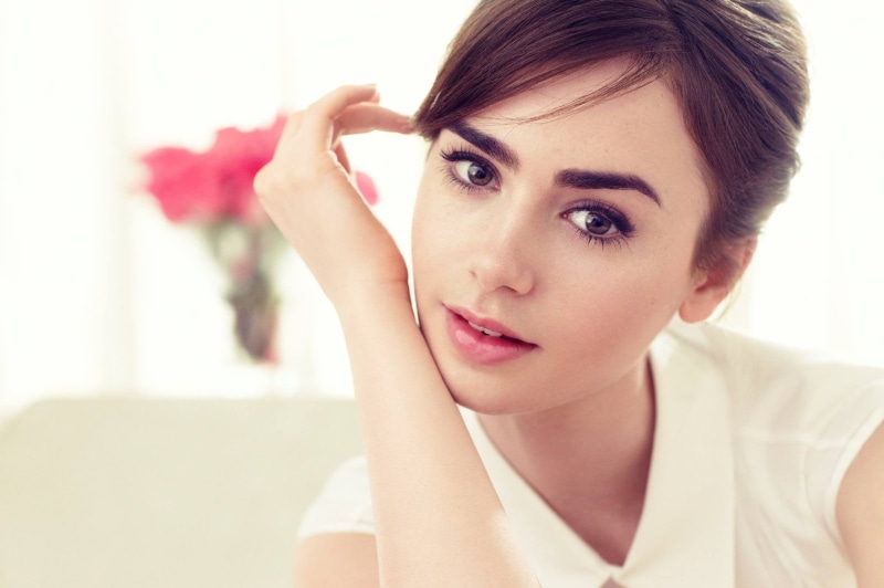 touching face, beautiful woman, brown eyes, young adult, front view, adult, young women, one person, hairstyle, beauty, looking at viewer, Lily Collins