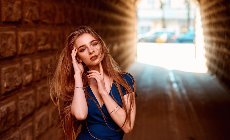 portrait, blue dress, women, model, earring, outdoors, touching face, dress, 2K, looking at viewer, women outdoors, hair in face, brunette, cleavage, long hair