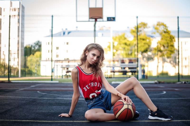 basketball, on the floor, sports jerseys, women outdoors, women, sneakers, basketball court, looking at viewer, 2K, outdoors, depth of field, ball, spread legs
