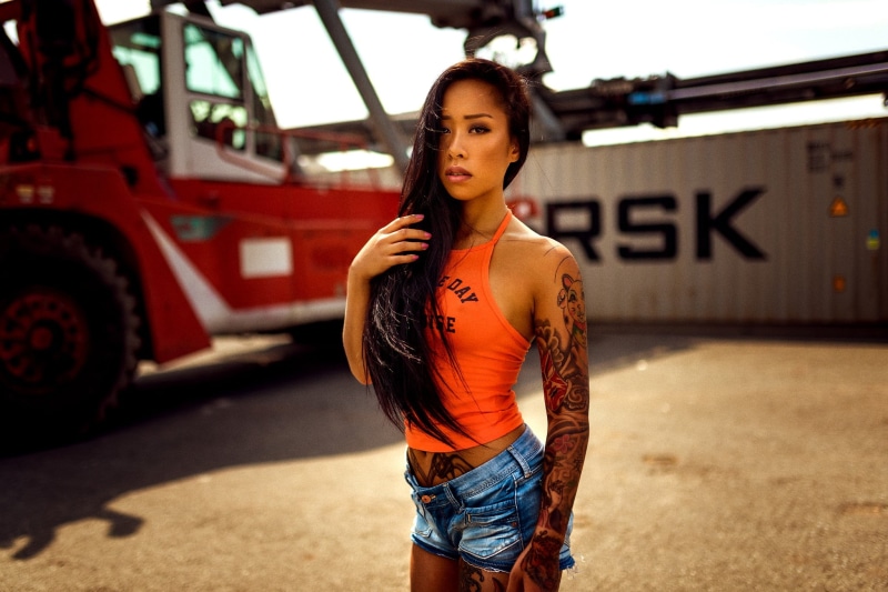 tattoo, 1080P, outdoors, looking at camera, three quarter length, leisure activity, jean shorts, fashion, front view, portrait, hairstyle, beautiful woman