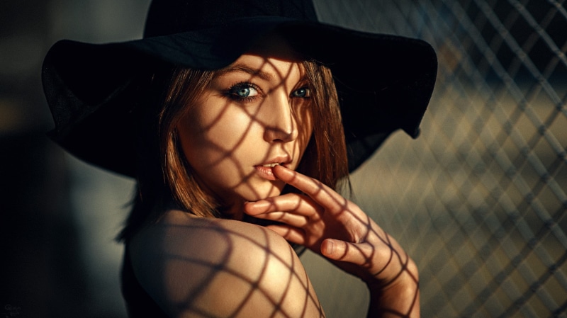 bare shoulders, fence, Georgy Chernyadyev, hat, women, face, 1080P, Olya Pushkina, finger in mouth, portrait, blue eyes, model, brunette, shadow
