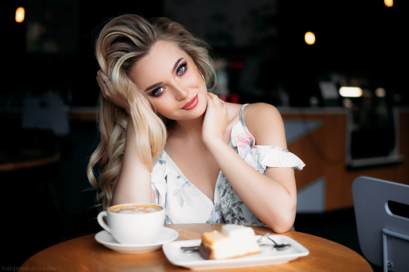 table, looking at viewer, blue eyes, cafeteria, makeup, make up, 1080P, dress, Ivan Proskurin, cup, caffe, long hair, smiling, pink lipstick, blonde, portrait