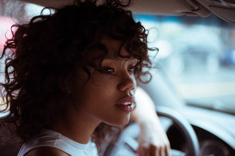 one person, mode of transportation, adult, emotion, hairstyle, hair, motor vehicle, 720P, car, curly hair, transportation, young women, indoors, brown hair