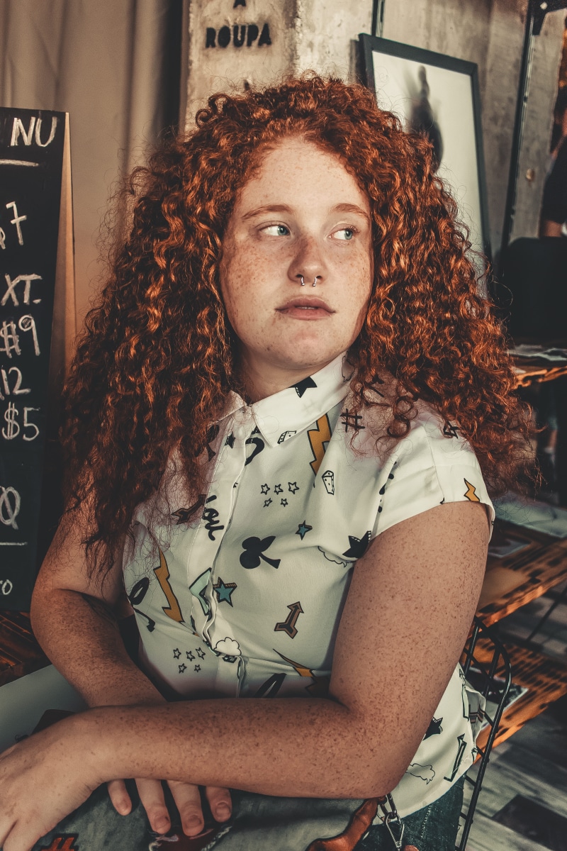 indoors, leisure activity, frizzy, casual clothing, beautiful, sitting, looking at camera, hairstyle, person, 5K, front view, beauty, curly hair, waist up