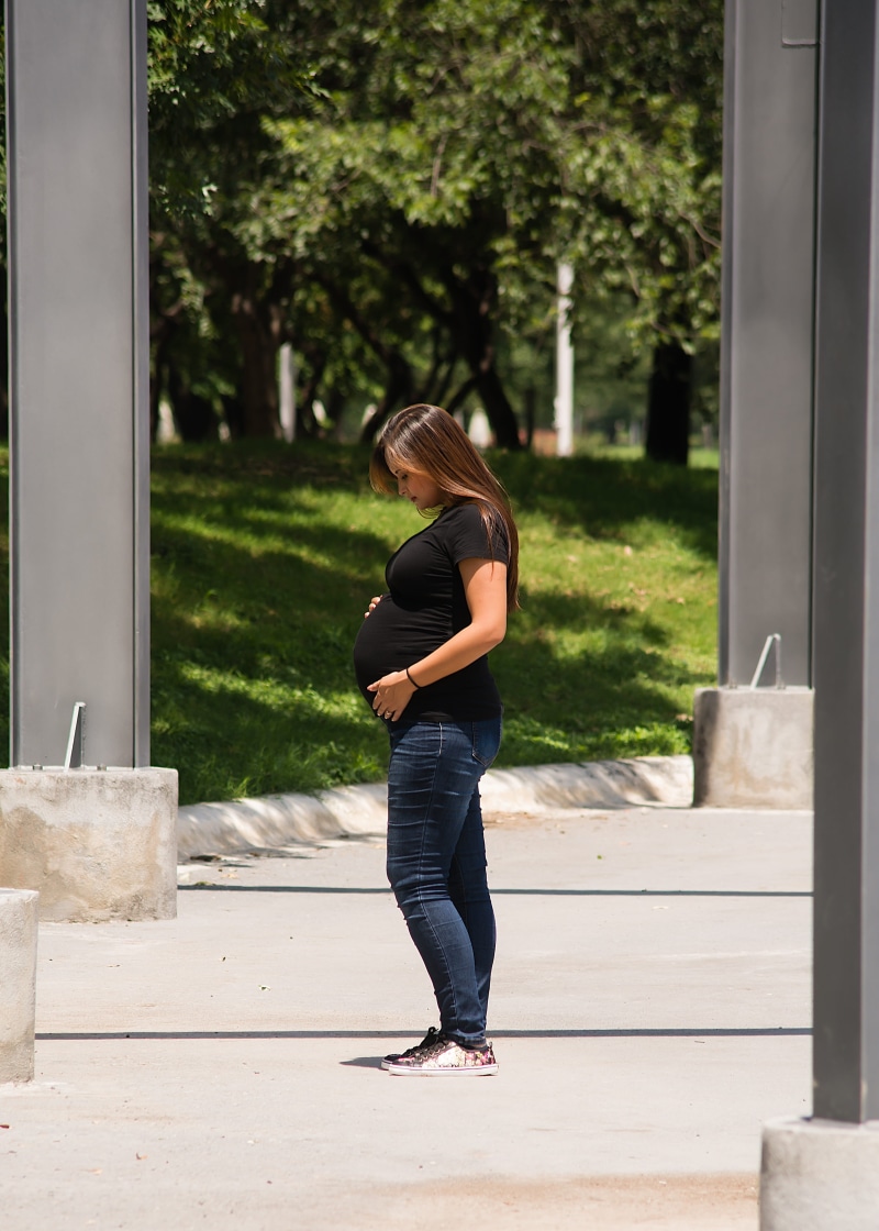 outdoors, footpath, pregnant, plant, real people, architecture, building exterior, casual clothing, sunlight, side view, hairstyle, lifestyles, 4K, standing