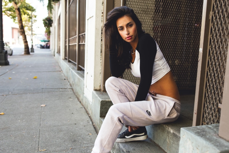 casual clothing, sneakers, skinny, one person, leisure activity, young adult, sitting, front view, contemplation, young women, day, real people, full length