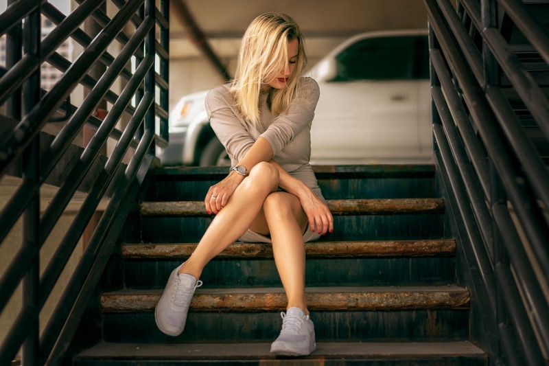 hopelessness, blonde, young women, full length, real people, emotion, beautiful woman, adult, staircase, sitting, long hair, seat, hair, young adult, depression - sadness