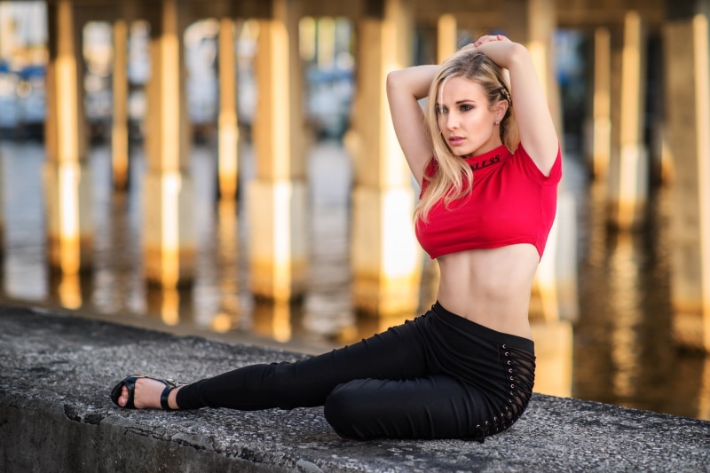 full length, beautiful woman, hair in face, young adult, pink nails, depth of field, focus on foreground, adult, real people, pants, sports clothing, armpits