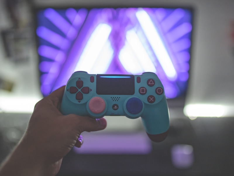 screen, lifestyles, joystick, video gaming, electronics, finger, human limb, purple, holding, one person, console, games, activity, bokeh, minecraft