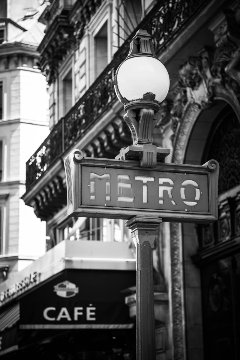 number, day, transport, focus on foreground, store sign, city, urban, built structure, outdoors, train, road sign, text, guidance, no people, building