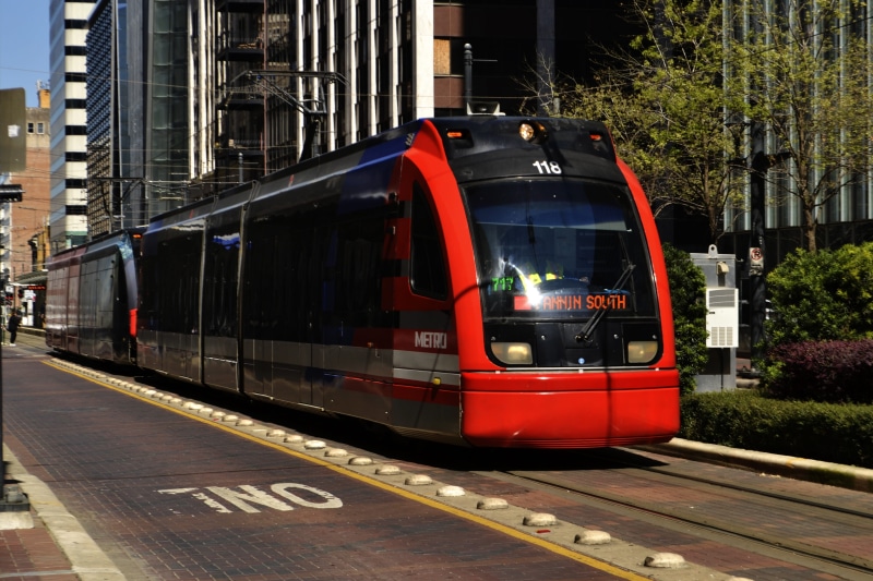 tram, building, high-rise, transportation system, train, railroad station platform, on time, road, downtown, car, urban, public, architecture, outdoor