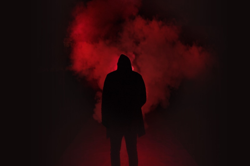 smoke - physical structure, indoors, one person, light, back lit, three quarter length, black background, depression - sadness, art, standing, red, fog
