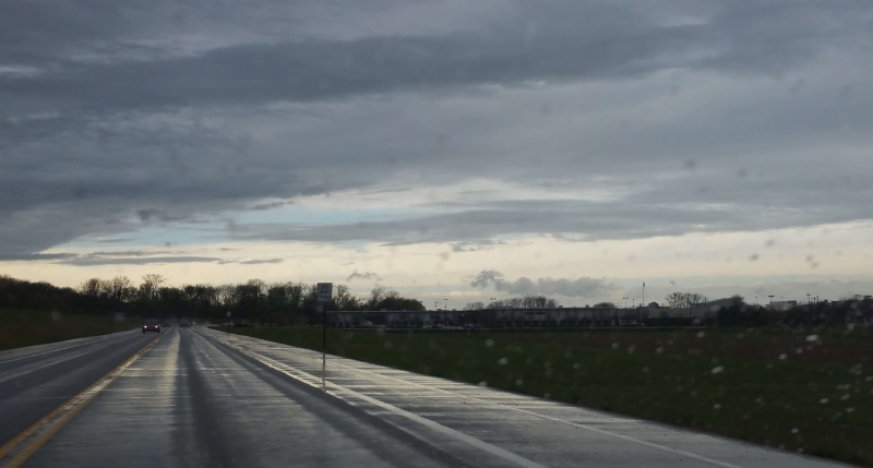 mode of transportation, road, vanishing point, raindrops, tree, cloud - sky, street, day, sign, stormy, showers, no people, transportation, symbol, drive