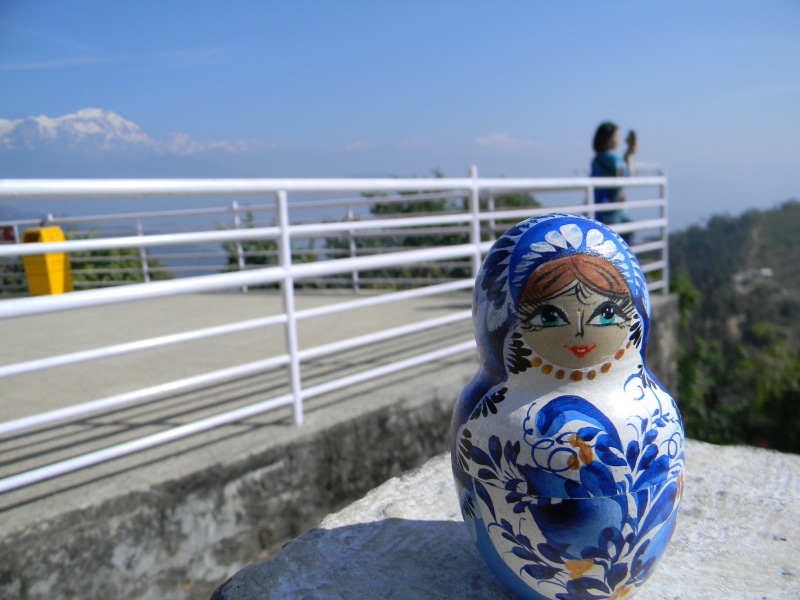 human representation, small fresh, toy, blue, matryoshka, sunlight, craft, pokhara, focus on foreground, railing, female likeness, male likeness, nepal